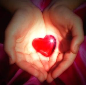 two-hands-holding-a-glowing-heart
